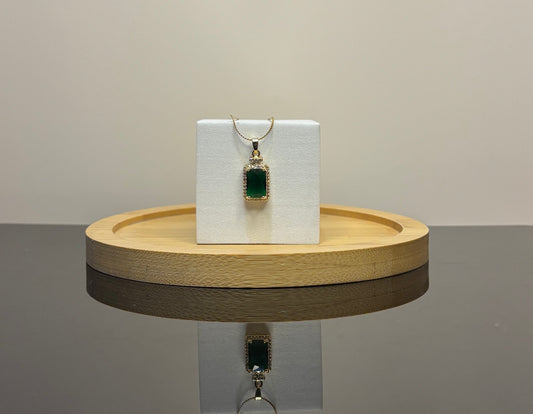 green  pendant on a white card with a wooden stand against a neutral background