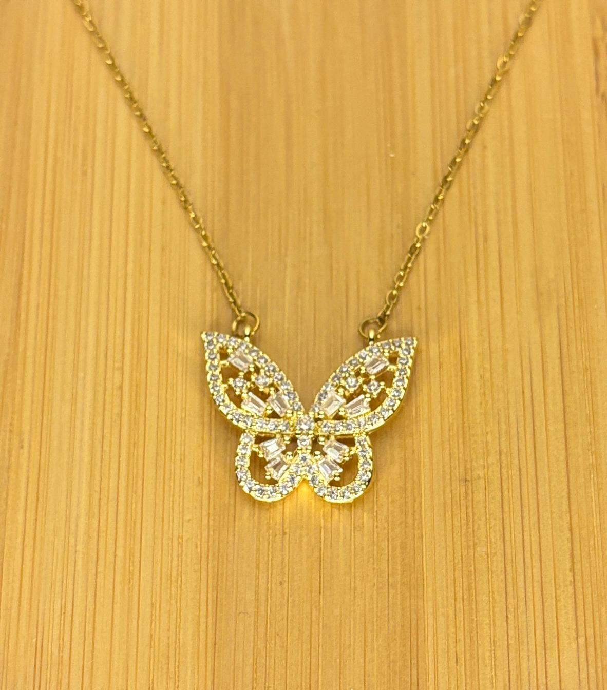 Gold butterfly necklace on a wooden surface