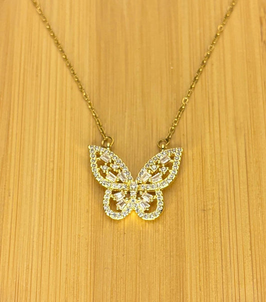 Gold butterfly necklace on a wooden surface