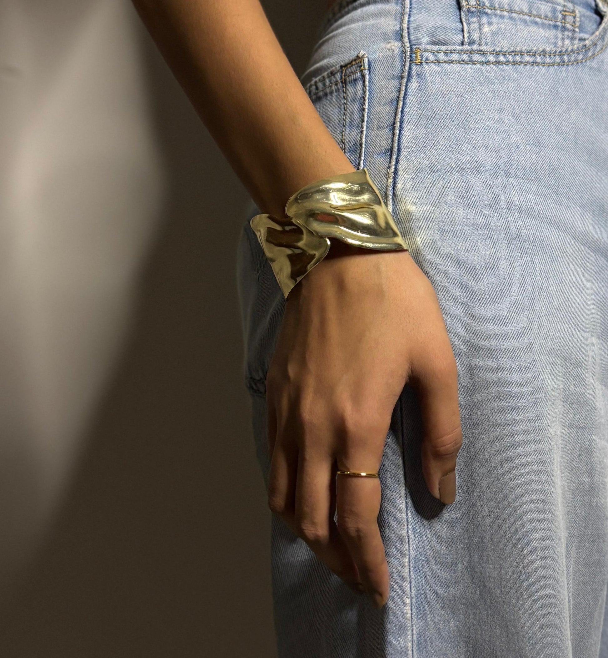 Gold bracelet on a wrist with a blurred background
