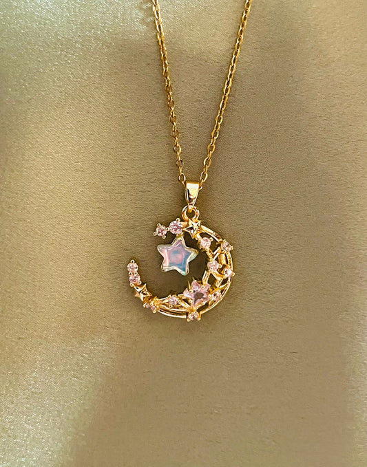 Gold necklace with a moon and star pendant on a gold background