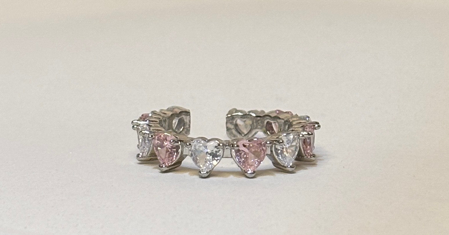 Silver ring with heart-shaped gemstones on a light background