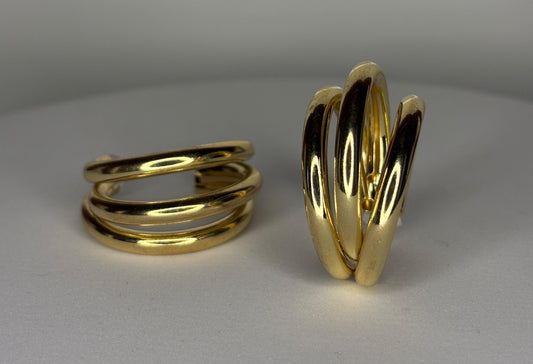 gold spiral hoop earrings on a gray background